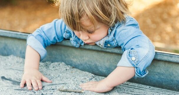 Ребенок играет в песочнице и заражен червями